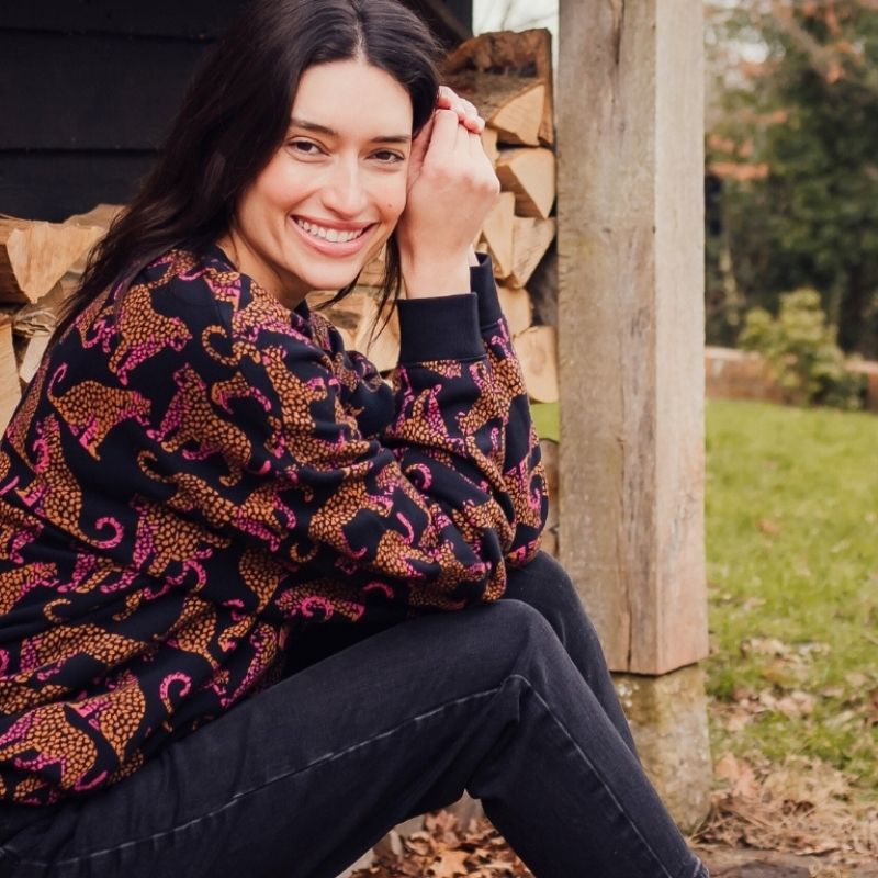 woman sat wearing leopard print jumper 