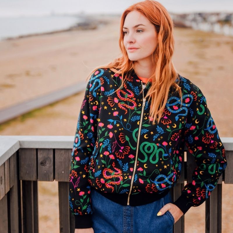 a model wearingt a snake print bomber jacket 