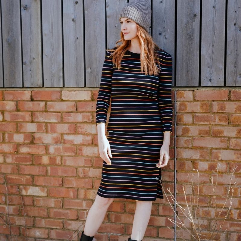 a woman modelling a dress stood by a wall 