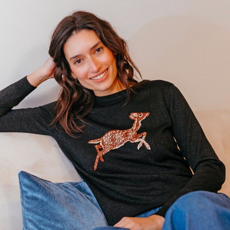 a close up of a model wearing a sparkle deer jumper 