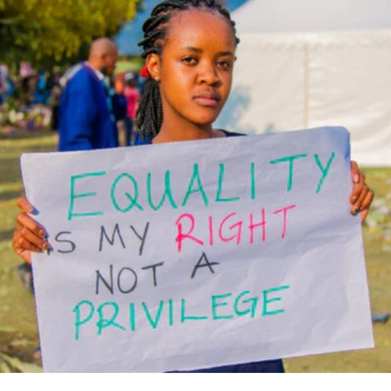 a woman holding a sign 