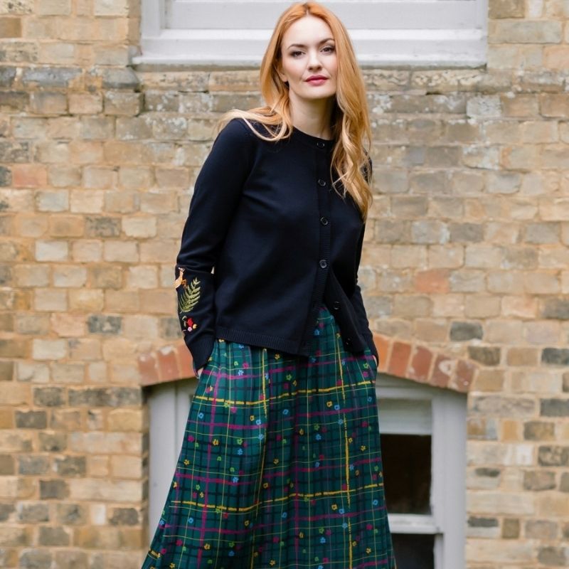 A woman wearing a green checked skitt