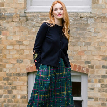 A woman wearing a green checked skitt