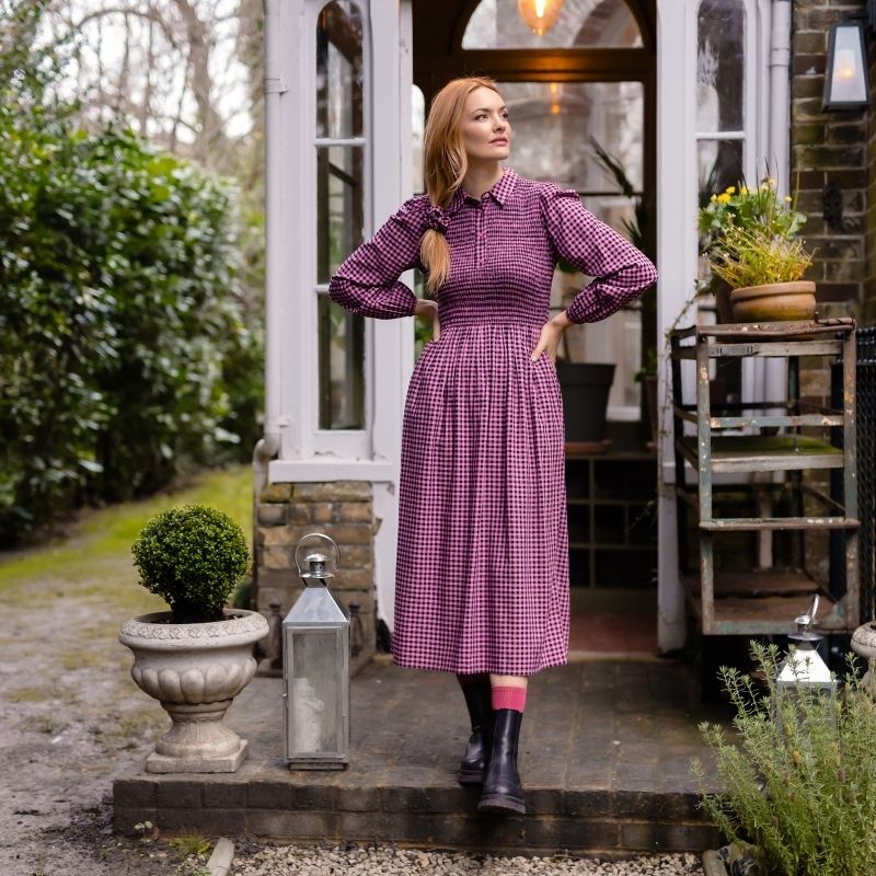 a woman wearing a pink gingham dress