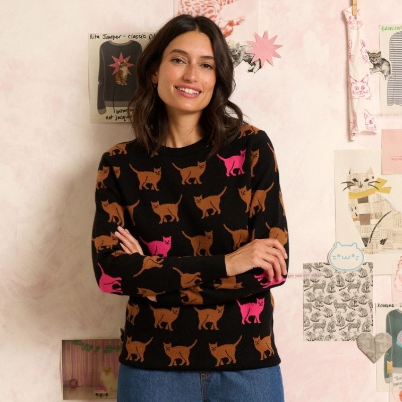 WOMAN MODCELLING A BLACK JMPER WITH CATS ON 