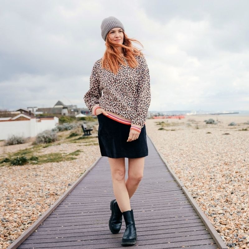 woman walking along the beach in leopard print jumper 