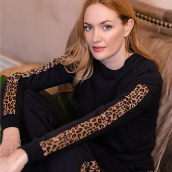 a woman wearing a leopard print trim sweatshirt 