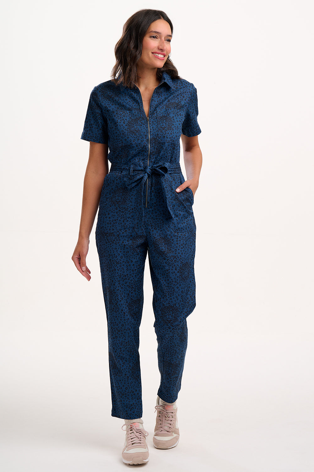 Sugarhill Brighton model wearing a blue jumpsuit on a white background