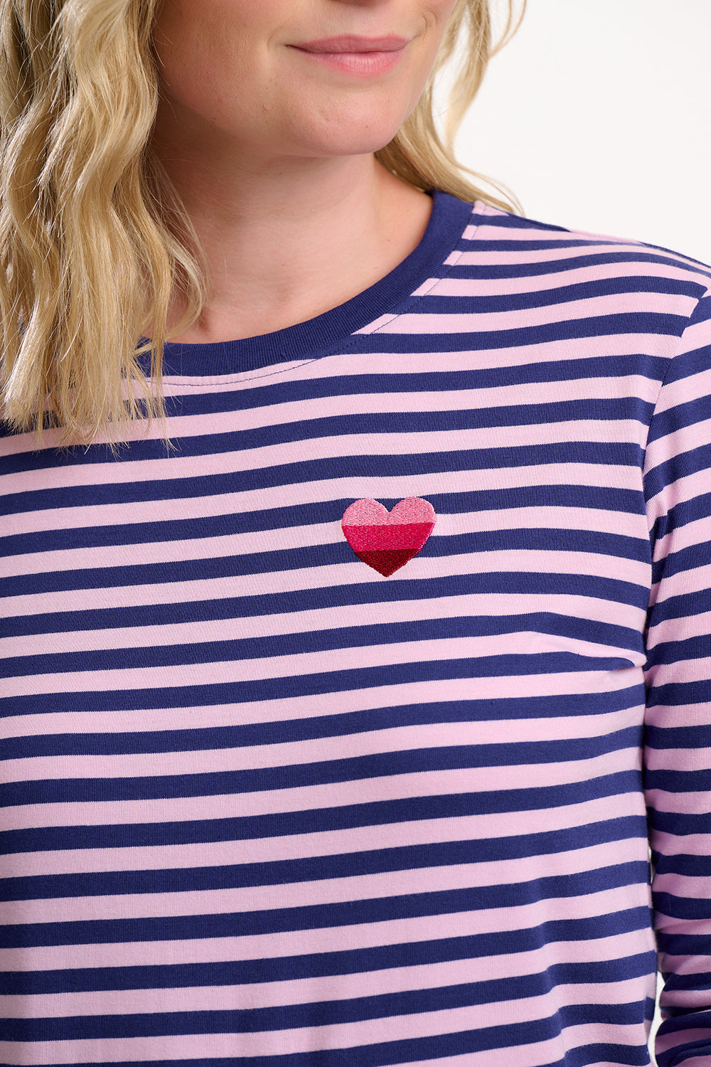 Sugarhill Brighton navy and pink striped shirt with a heart design on a plain background