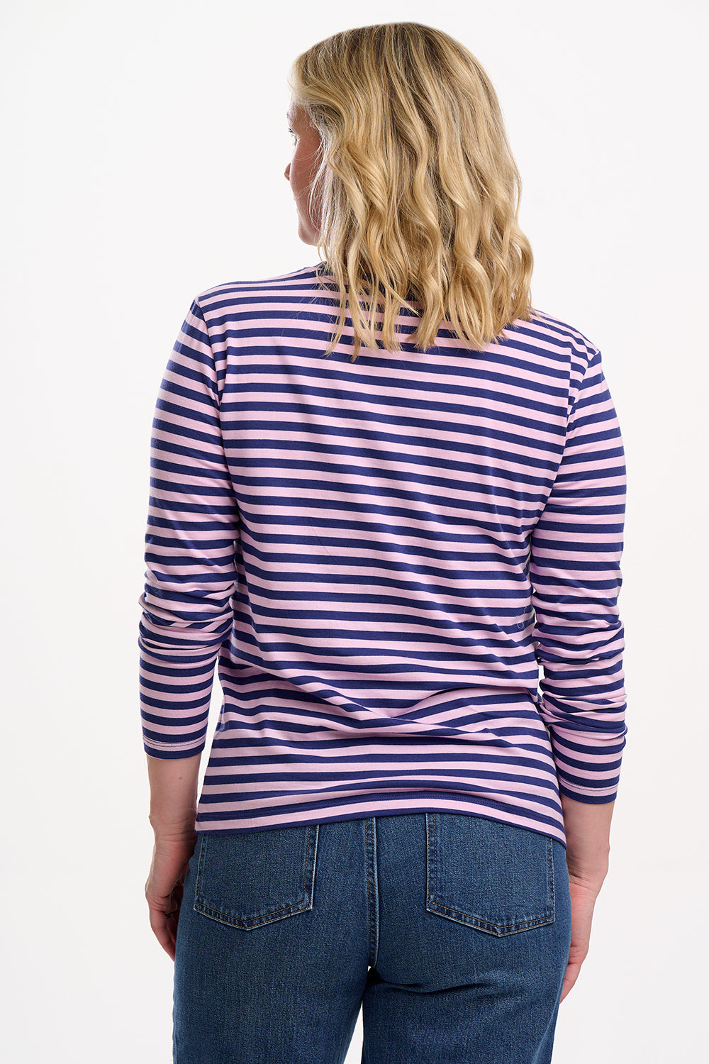 Sugarhill Brighton model wearing a striped long-sleeve shirt and jeans on a white background