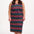A model wearing a sleeveless midi dress with a wavy chevron stripe pattern in black, teal, navy, tan, pink, and coral colors.
