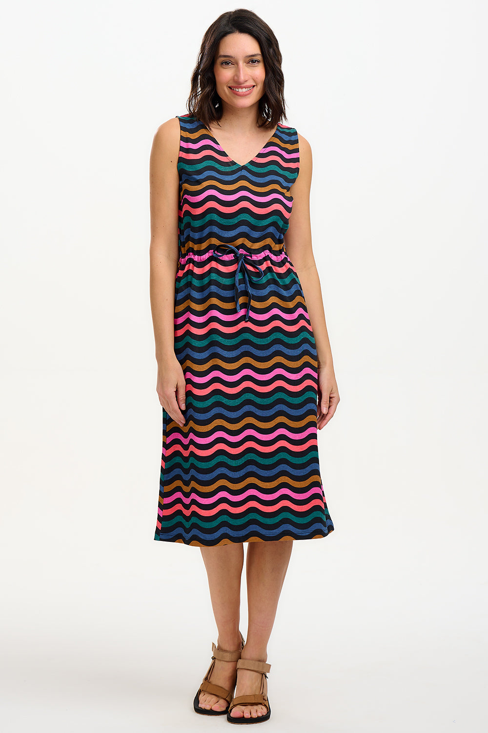 A model wearing a sleeveless midi dress with a wavy chevron stripe pattern in black, teal, navy, tan, pink, and coral colors.