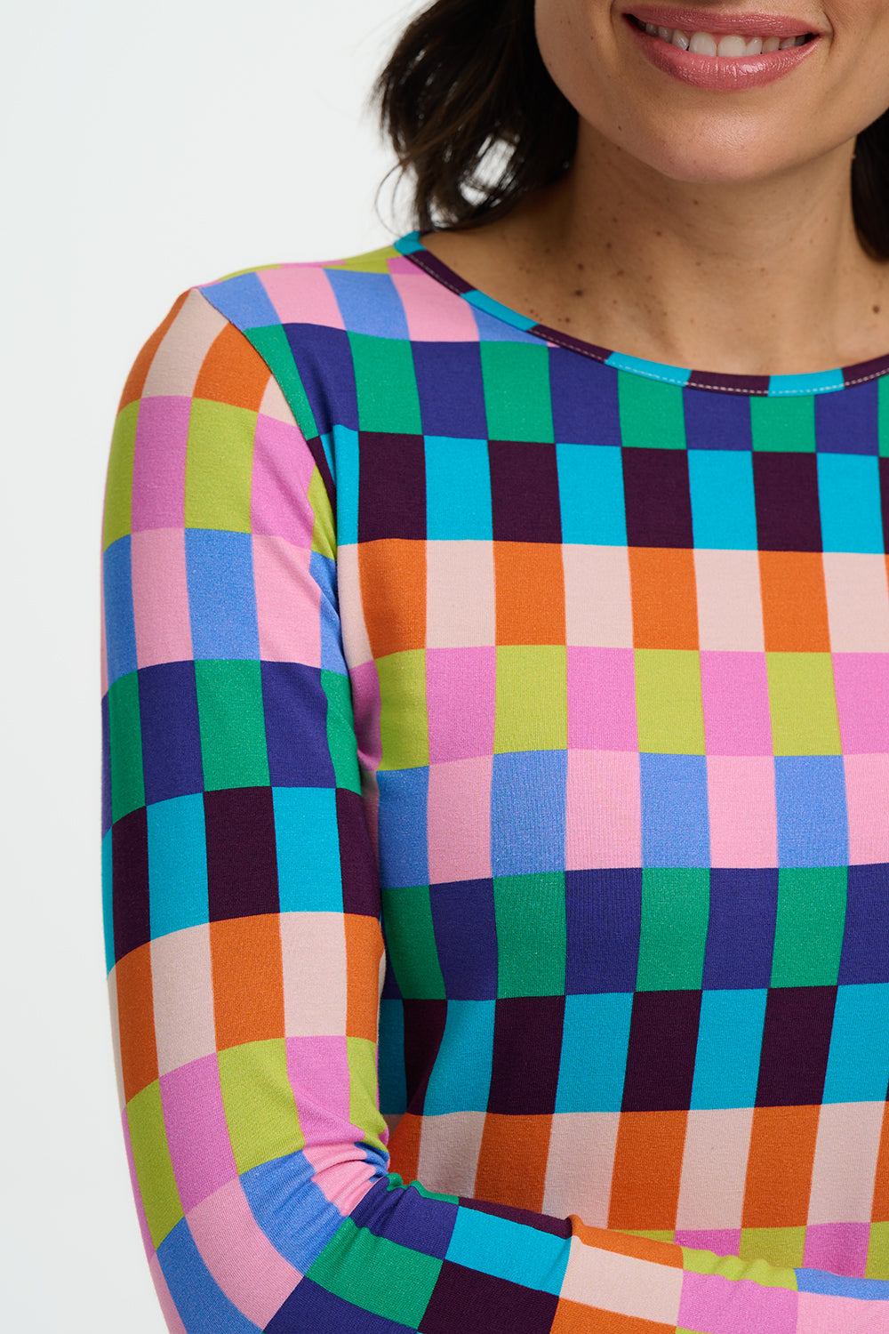 Multicolored checkered shirt worn by a person on a white background