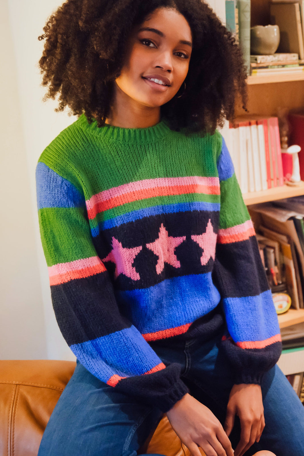 A woman wearing a colorful striped sweater with a pattern of stars.