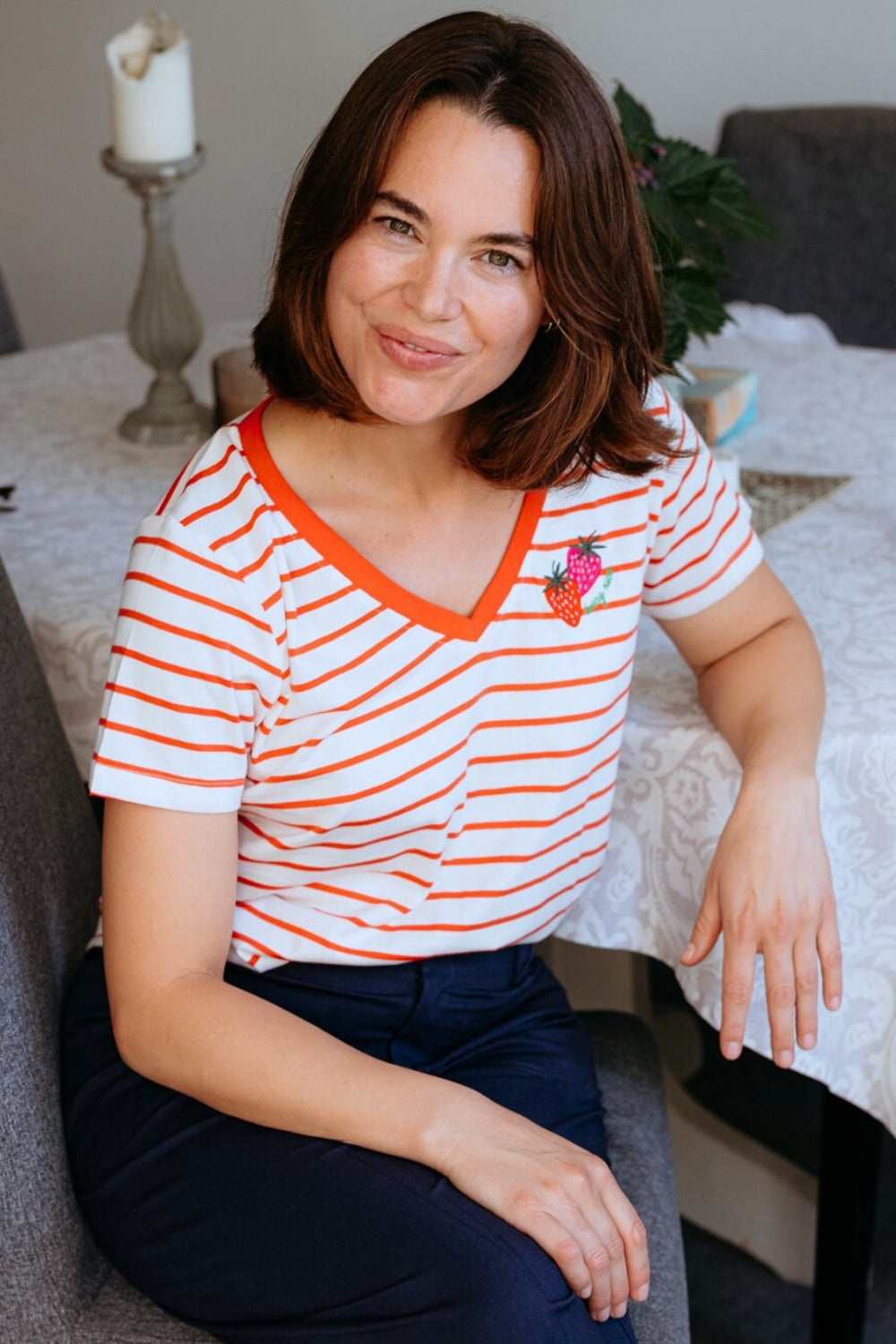 Woman wearing a striped shirt sitting in a living room.