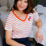 Woman wearing a striped shirt sitting in a living room.