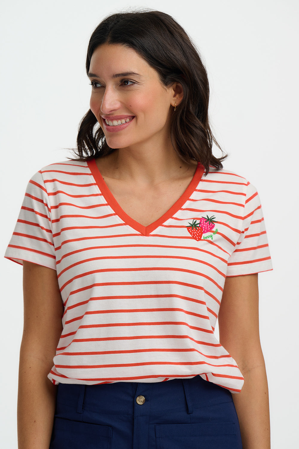 Woman wearing a red and white striped shirt with a strawberry design on a white background