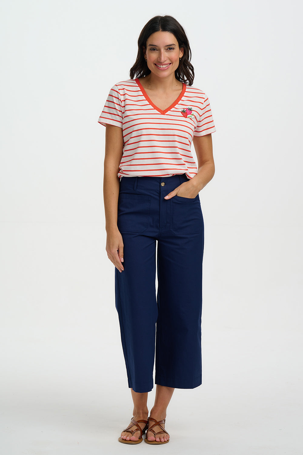 Woman wearing a red and white striped shirt and blue pants on a white background