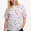 Sugarhill Brighton model wearing a white t-shirt with colorful abstract pattern on a white background