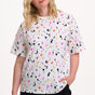 Sugarhill Brighton model wearing a white t-shirt with colorful abstract pattern on a white background