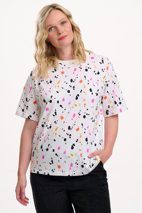 Sugarhill Brighton model wearing a white t-shirt with colorful abstract pattern on a white background