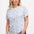 A woman wearing an off-white t-shirt with a blue leopard spot pattern