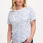 A woman wearing an off-white t-shirt with a blue leopard spot pattern