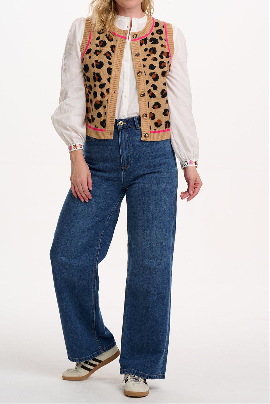 Suagrhill Brighton model wearing a leopard print vest over a white shirt with blue jeans on a white background
