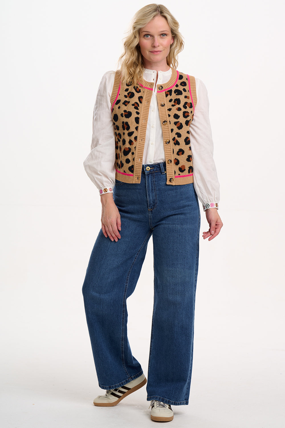 Suagrhill Brighton model wearing a leopard print vest over a white shirt with blue jeans on a white background