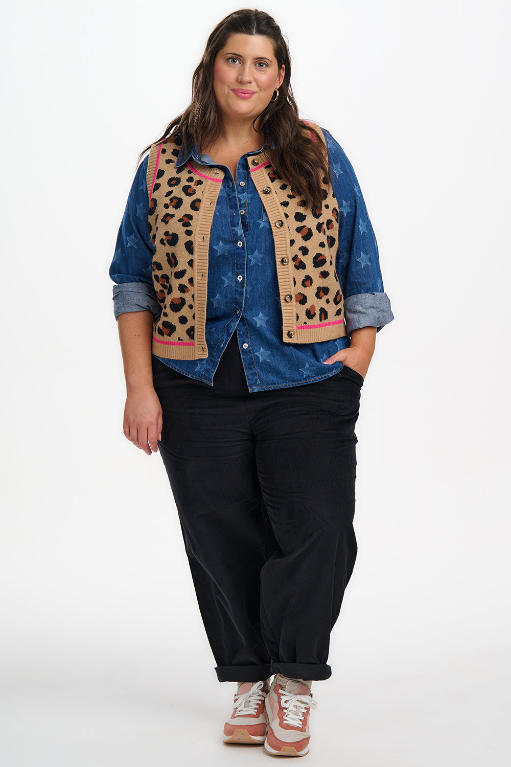 Woman wearing a denim jacket with leopard print accents on a white background