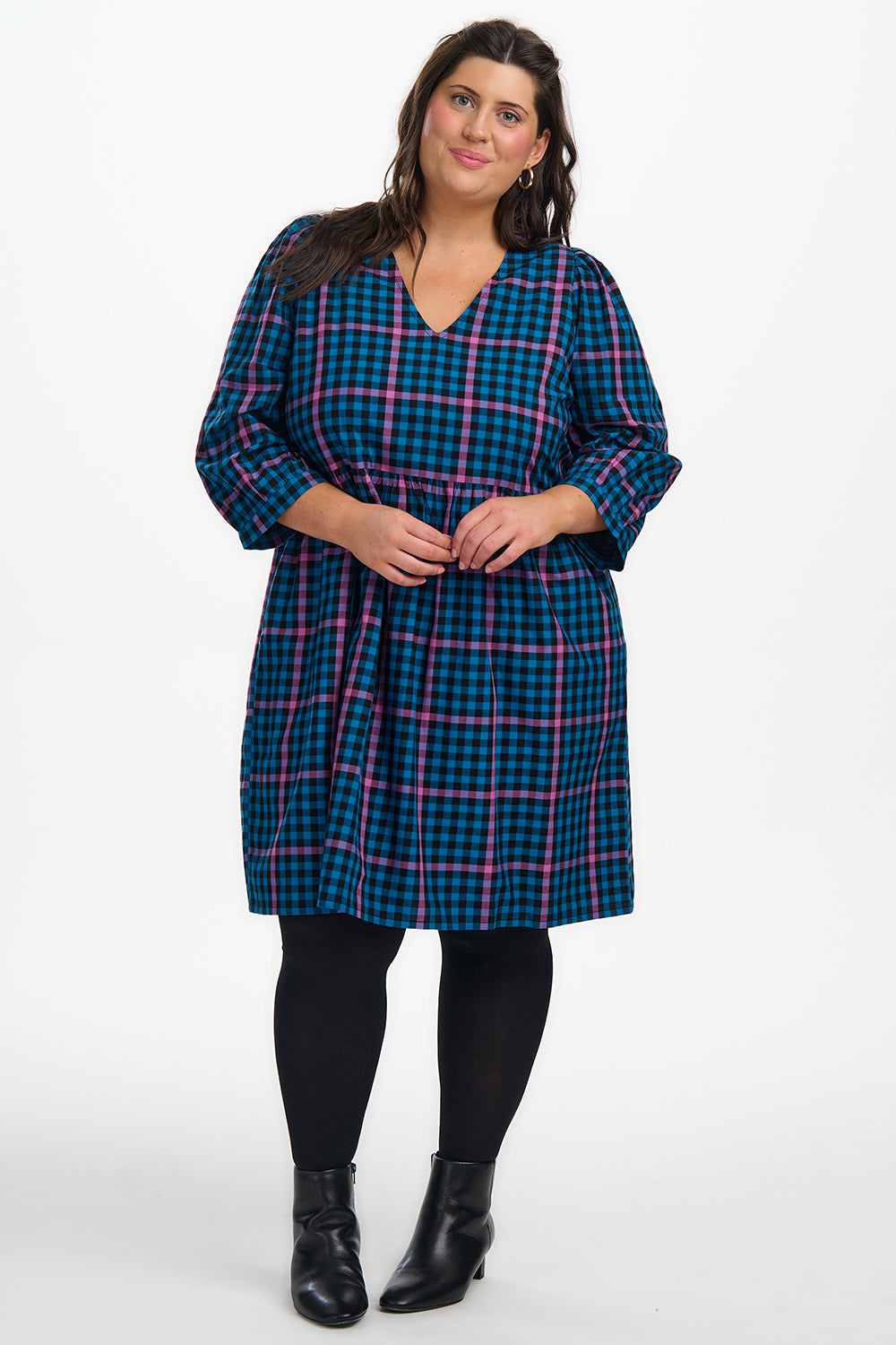 Woman wearing a blue and pink plaid dress on a white background