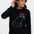 Woman wearing a black sweater with a cat design on a white background