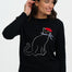 Woman wearing a black sweater with a cat design on a white background