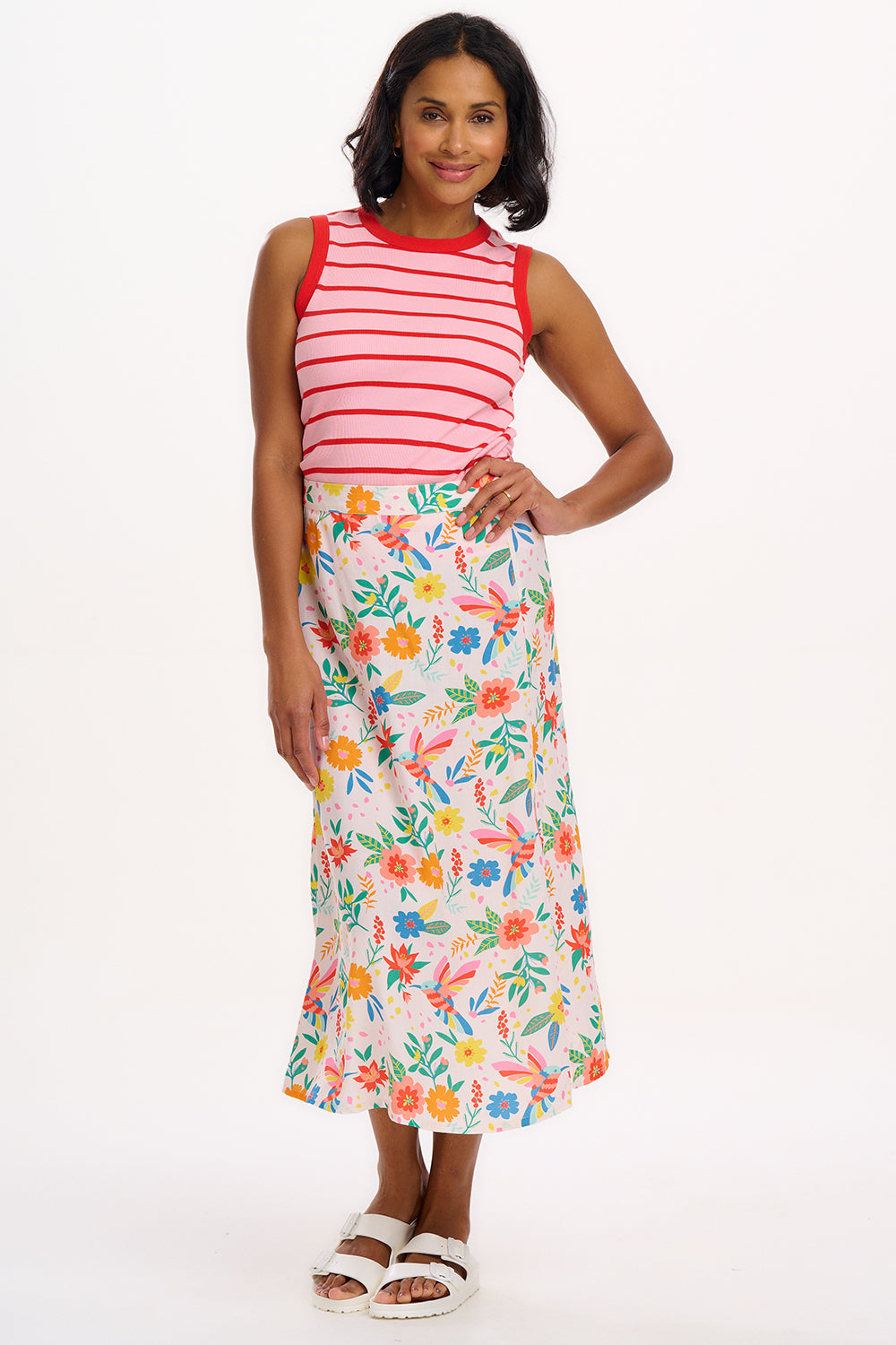 A woman wearing a sleeveless fitted pink vest with red stripes, round neckline, and contrast bands around the arm holes.
