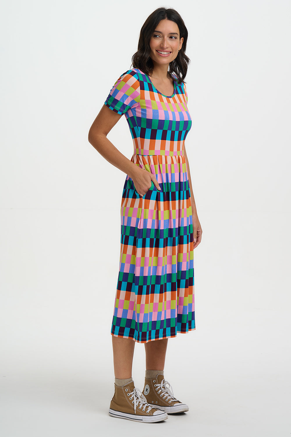 Woman wearing a colorful checkered dress on a white background