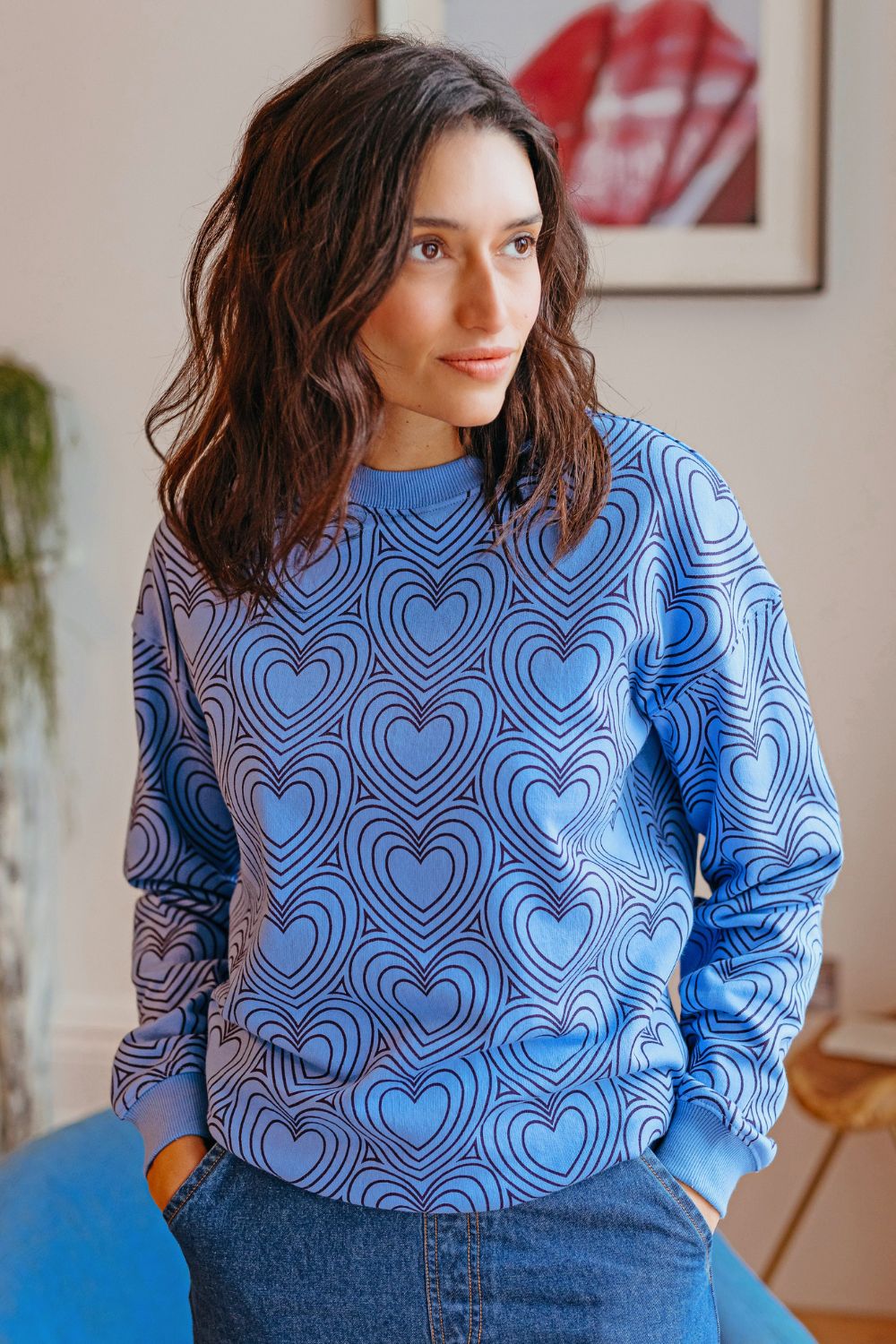Woman wearing a blue sweater with heart pattern indoors