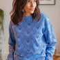 Woman wearing a blue sweater with heart pattern indoors
