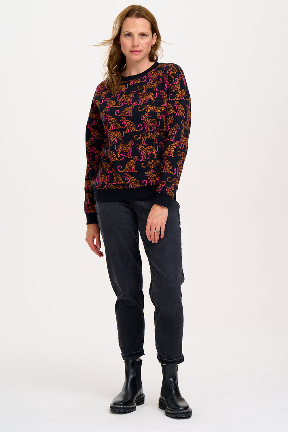 A Sugarhill Brighton model wearing a black sweatshirt with a two-tone leopard print pattern, paired with black trousers.