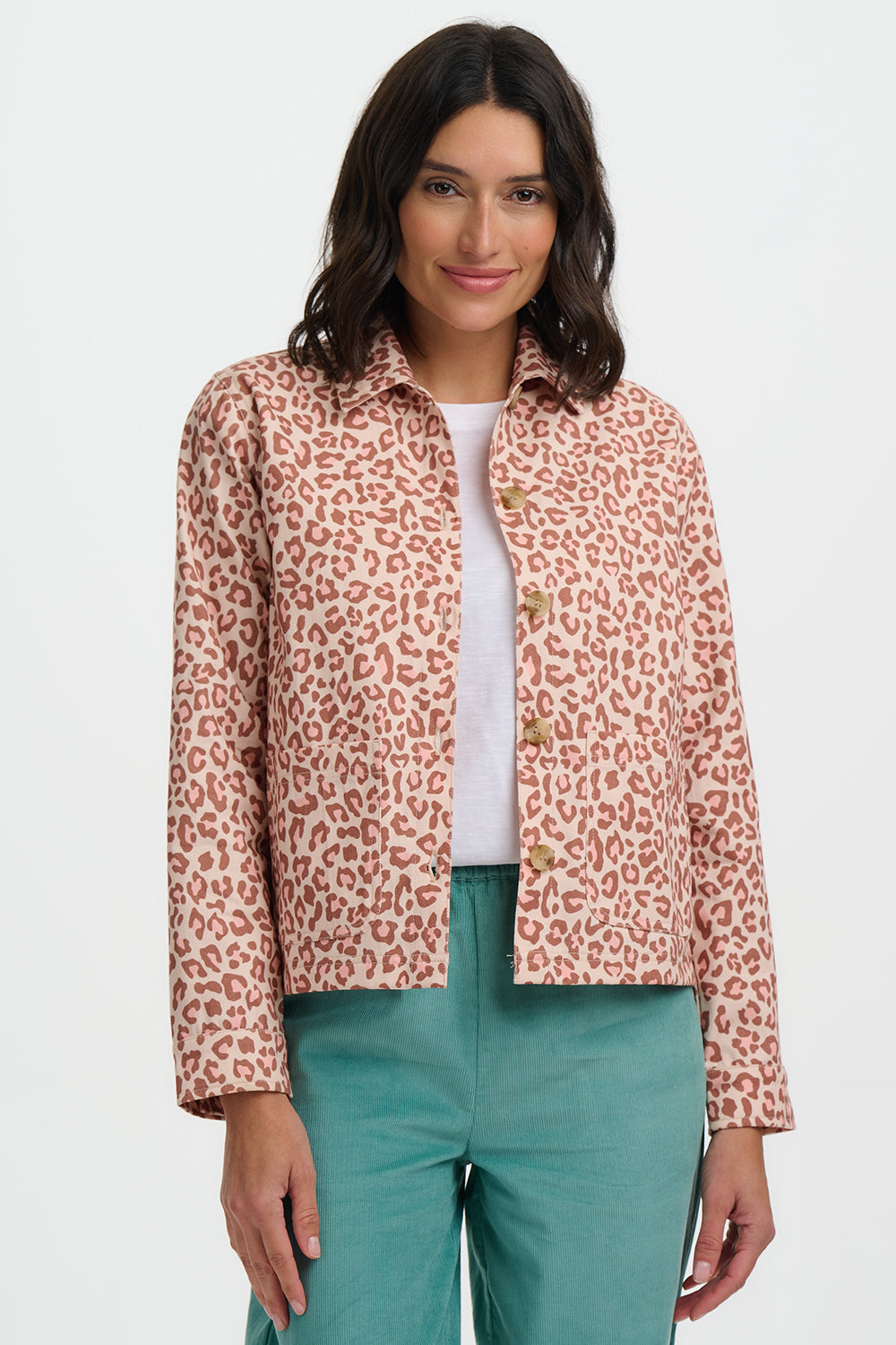 Woman wearing a leopard print jacket over a white shirt and green pants on a white background