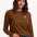 Sugarhill Brighton - model wearing a black and orange striped long-sleeve shirt with a small logo on a white background