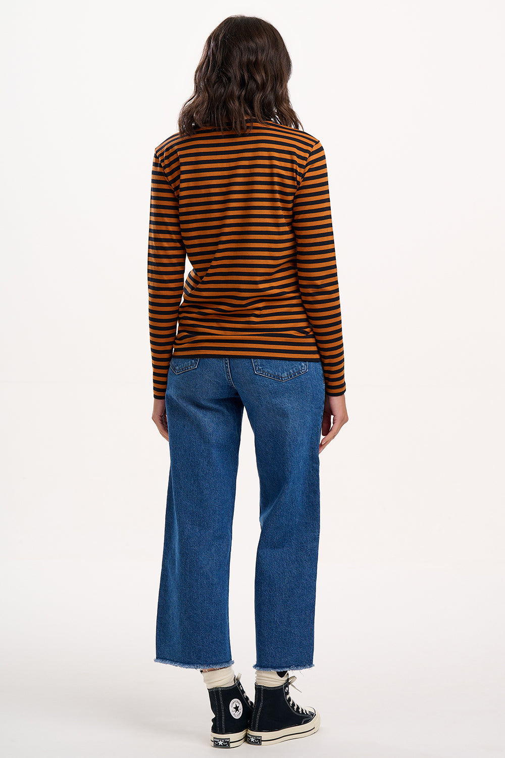Sugarhill brighton - Model wearing a striped shirt and blue jeans on a white background