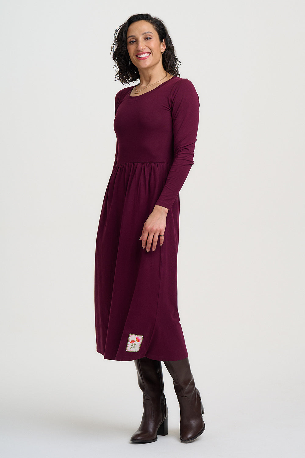 Woman wearing a burgundy dress with a white background