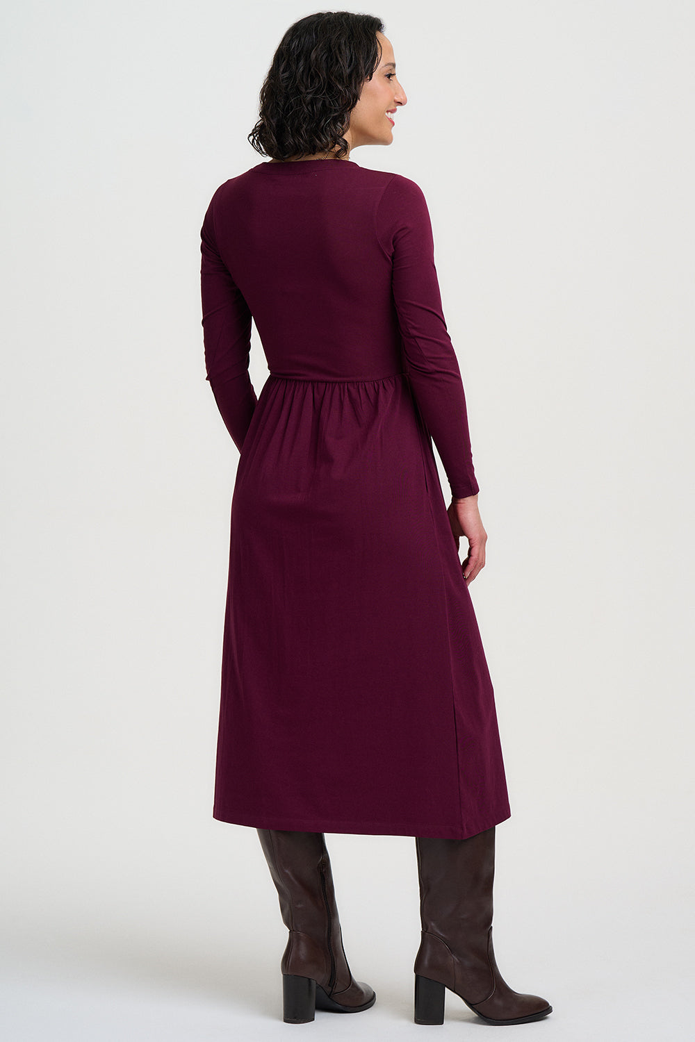 Woman wearing a long burgundy dress on a white background