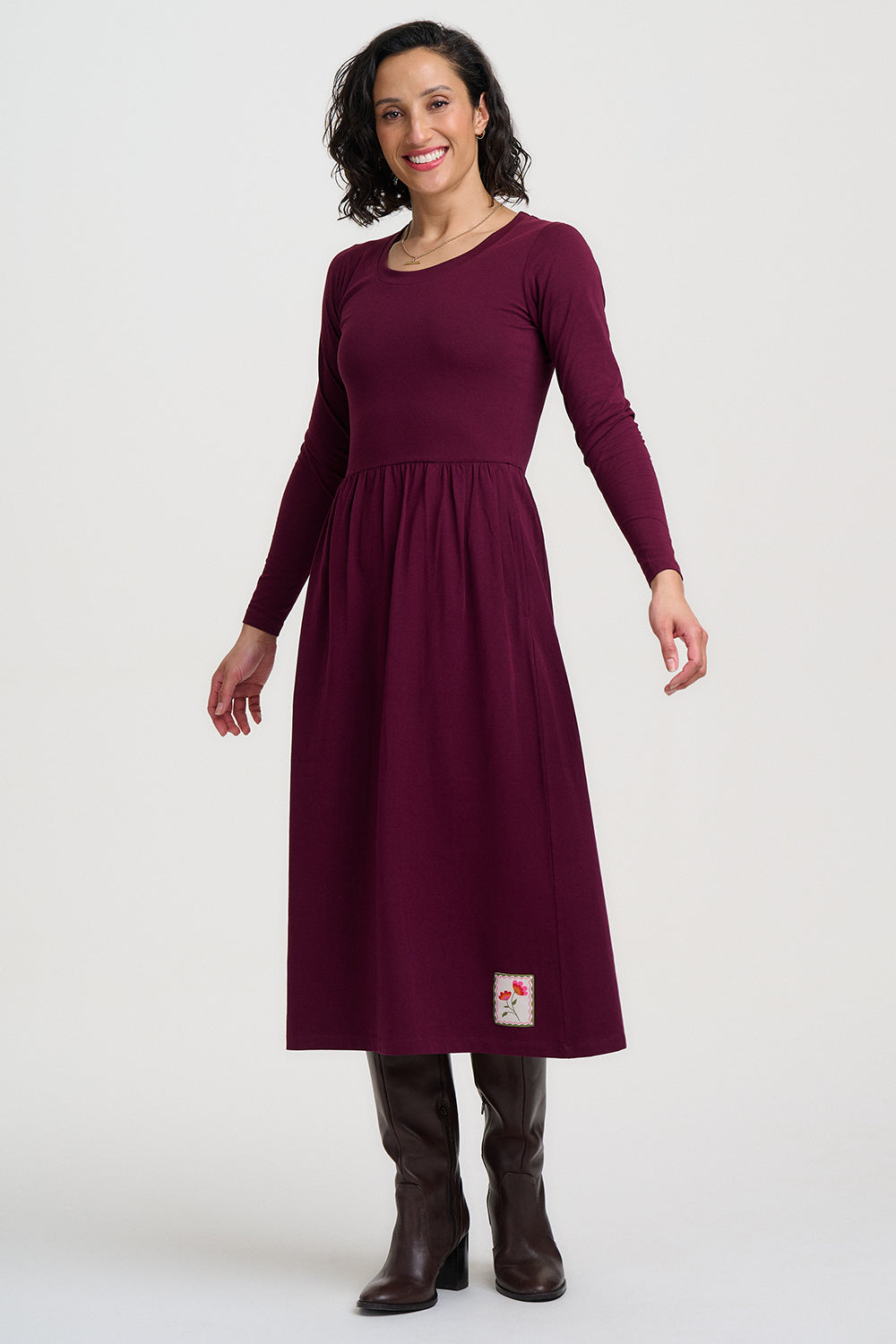 Woman wearing a burgundy dress with a white background