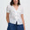 Woman wearing a white blouse with ruffles and blue shorts on a white background