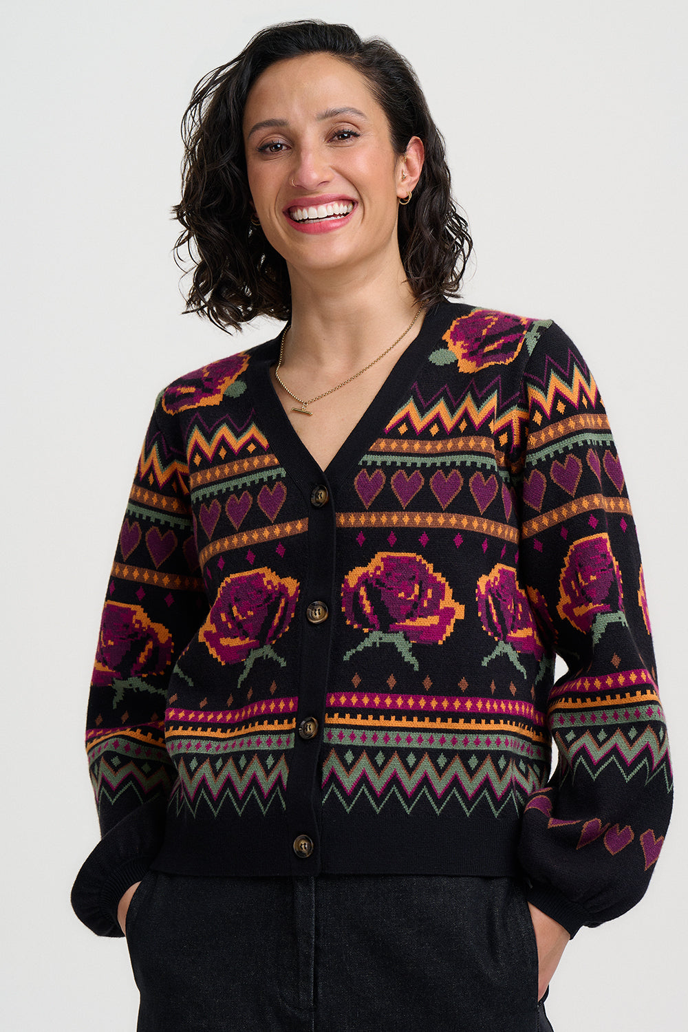 Woman wearing a black cardigan with colorful floral patterns on a white background