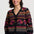 Woman wearing a black cardigan with colorful floral patterns on a white background