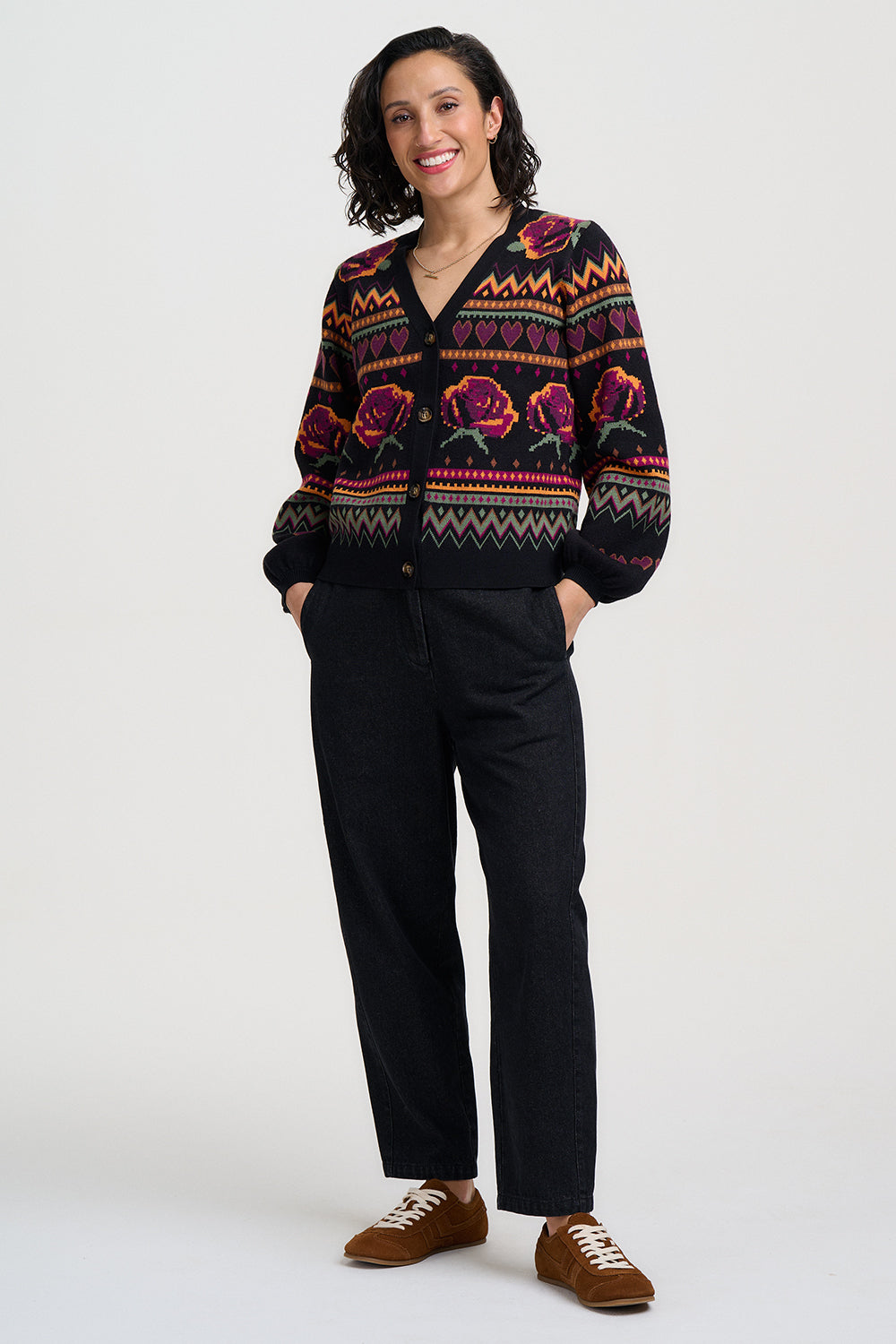 Woman wearing a patterned cardigan with a plain background
