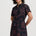 Woman wearing a black dress with red patterns on a white background