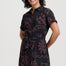 Woman wearing a black dress with red patterns on a white background